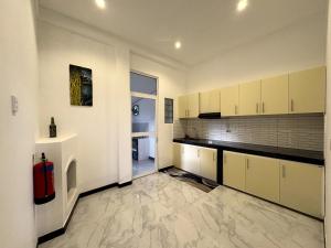 an empty kitchen with white cabinets and a window at 7 Crowns Villa Ambewela, Nuwara Eliya in Boragasketiya