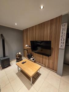 a living room with a coffee table and a flat screen tv at Casa de Ushuaia in Ushuaia