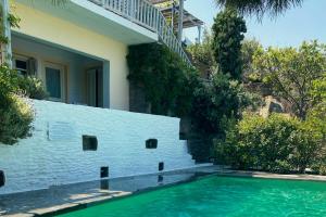 a swimming pool in front of a house with a staircase at Blue & Earth Kea in Ioulis