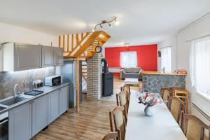 a kitchen and living room with a table and chairs at Vilka Cibulka a chata Cesnačik in Ižipovce