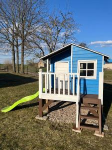 a blue and white play house with a green slide at Agroturystyka u Grażki in Szostakowo