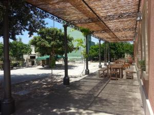 an outdoor patio with a wooden table and benches at Piccapane Vegan Farm in Cutrofiano