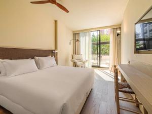 a bedroom with a large white bed and a window at Mercure Benidorm in Benidorm
