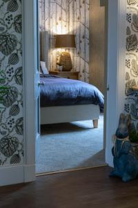 a bedroom with a bed and a door leading into a room at The Painted Cow in Beattock +6 photos