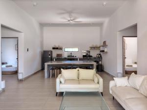 a living room with two white couches and a table at Bayu Beach House in Cherating
