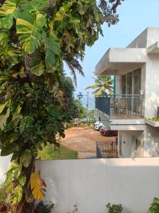 a view of a house with a tree at Basuri Beach Resort in Varkala