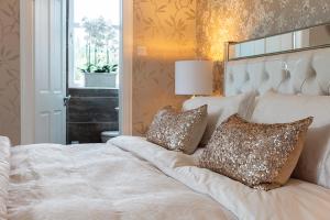 a bedroom with a large white bed with two pillows at The Painted Cow in Beattock