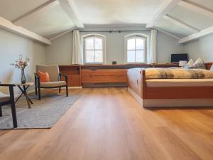 a bedroom with a bed and a desk and a chair at Pension Villa Bergkristall in Eschenlohe +51 photos