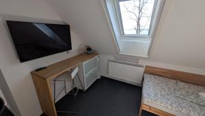 a room with a desk with a television and a window at Ubytování Tři Vrby in Pasohlávky