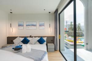 a bedroom with a bed and a balcony with a pool at Baby Blue pool villa in Ban Bo Prakhon +83 photos