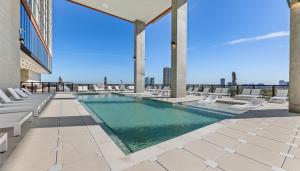 a swimming pool on the roof of a building with chairs at Sentral Forme Houston in Houston