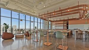 a large room with tables and chairs and large windows at Sentral Forme Houston in Houston