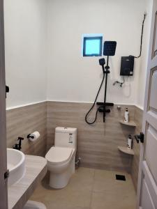 a bathroom with a toilet and a camera on the wall at Bayu Beach House in Cherating