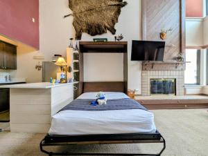 a bedroom with a bed with a teddy bear sitting on it at Edgewater 1448 by SummitCove Lodging in Colorado in Keystone +36 photos