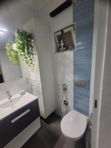 a bathroom with a white toilet and a sink at OrlaBela in Manta Rota