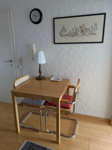 a wooden table with two chairs and a lamp on it at Pension Eltmann in Eltmann