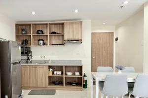 a kitchen with a table and a refrigerator at Suite Escape Mactan , condo with balcony near Mactan Newtown and Mactan Airport in Mactan