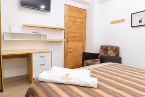 ein Hotelzimmer mit Bett und Schreibtisch in der Unterkunft Hotel partenon in Tacna