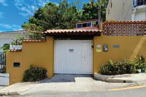 a yellow and white building with a white garage at Residencial Costa Loft in Angra dos Reis