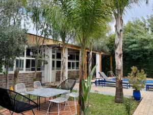 a patio with a table and chairs and trees at Riad Eglantine in Touggana