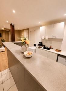 a kitchen with a vase of flowers on a counter at Logement accueillant in Gaillon +9 photos