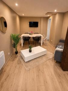 a living room with a white table and a couch at Logement accueillant in Gaillon