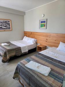 ein Hotelzimmer mit zwei Betten in einem Zimmer in der Unterkunft Hotel partenon in Tacna