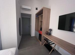 ein Schlafzimmer mit einem Flachbildfernseher an der Wand in der Unterkunft Rooms Around in Neapel