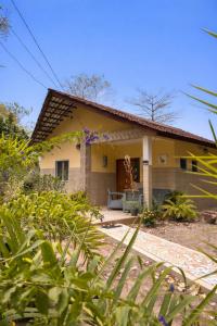 a small yellow house with a porch at Busy Bee Nature Residence in Mariama Kunda