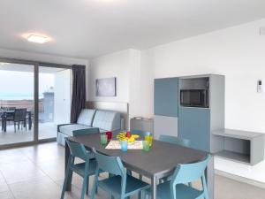 a kitchen and living room with a table and chairs at Modern flat in Piazza Fontana in Lignano Sabbiadoro