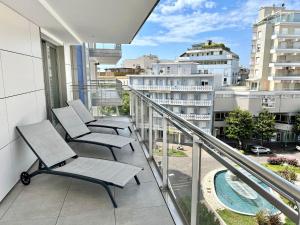 a balcony with chairs and a view of a city at Modern flat in Piazza Fontana in Lignano Sabbiadoro