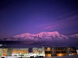 a view of a mountain at night with a building at Apartments with Panoramic Views in Longyearbyen