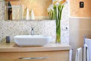 a bathroom with a sink and a vase of flowers at Villa Chia 2 in Chia