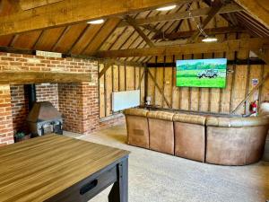 a large barn with a tv on the wall at Locks Lane Cottage in Geldeston