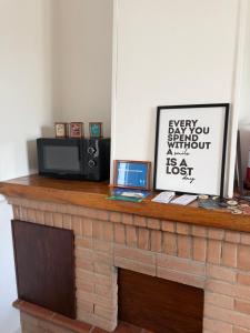 a brick fireplace with a microwave and a laptop on it at B&B Il Balcone Fiorito in Imola