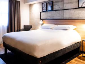 a bed in a hotel room with a large white bed at ibis Coleraine Riverside in Coleraine +100 photos