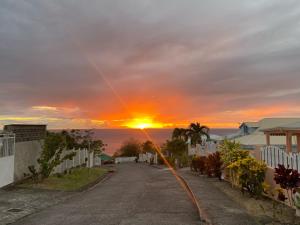an empty street with the sunset in the background at Roger et Micheline a Kaz in Le Carbet