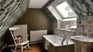 a bathroom with a tub and a sink and a chair at Aynetree Guest House in Edinburgh +76 photos