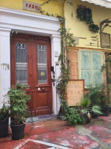 a wooden door of a house with plants on it at 1920's Rooms & Beds in Kalamata