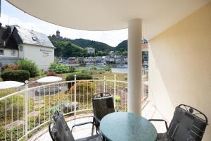 a balcony with a table and chairs and a view at Ferienwohnung am Moselufer in Cochem
