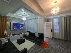 a living room with a couch and a flat screen tv at Casipe Transient House in Tanay
