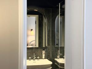 a bathroom with a sink and a toilet and a mirror at Neuilly Park Hotel in Neuilly-sur-Seine +49 photos