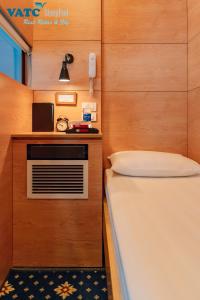 a small room with a bed and a microwave at VATC Sleep Pod Terminal 1 in Noi Bai