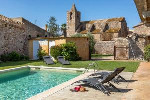 a swimming pool with chairs and a house at Can Marisch Les Arcades in Ventalló