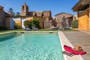 a swimming pool with a hat and a towel on a deck at Can Marisch Les Arcades in Ventalló
