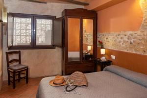 a bedroom with a bed with a hat and a chair at Can Marisch Les Arcades in Ventalló +22 photos
