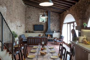 a dining room with a table and a living room at Can Marisch Les Arcades in Ventalló