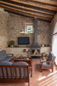a living room with a fireplace and a tv at Can Marisch Les Arcades in Ventalló