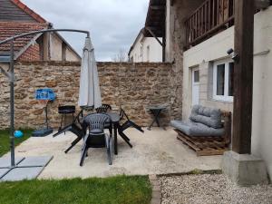 a patio with an umbrella and a table and chairs at La randonnée des vignobles in Essômes-sur-Marne