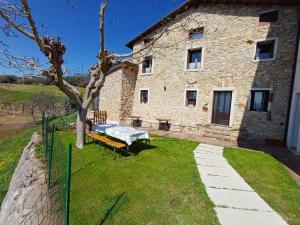 an old stone house with a picnic table in front of it at Al Colle Rooms in Montebello Vicentino
